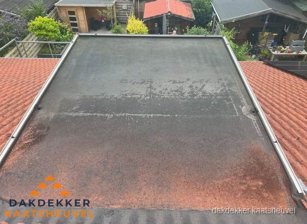 Verouderd plat dak met slijtage tussen schuine daken in Kaatsheuvel Verouderd plat dak met slijtage tussen schuine daken in Kaatsheuvel